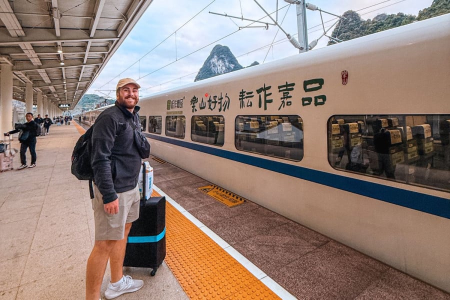 Traveller with suitcase by a train at a station in China