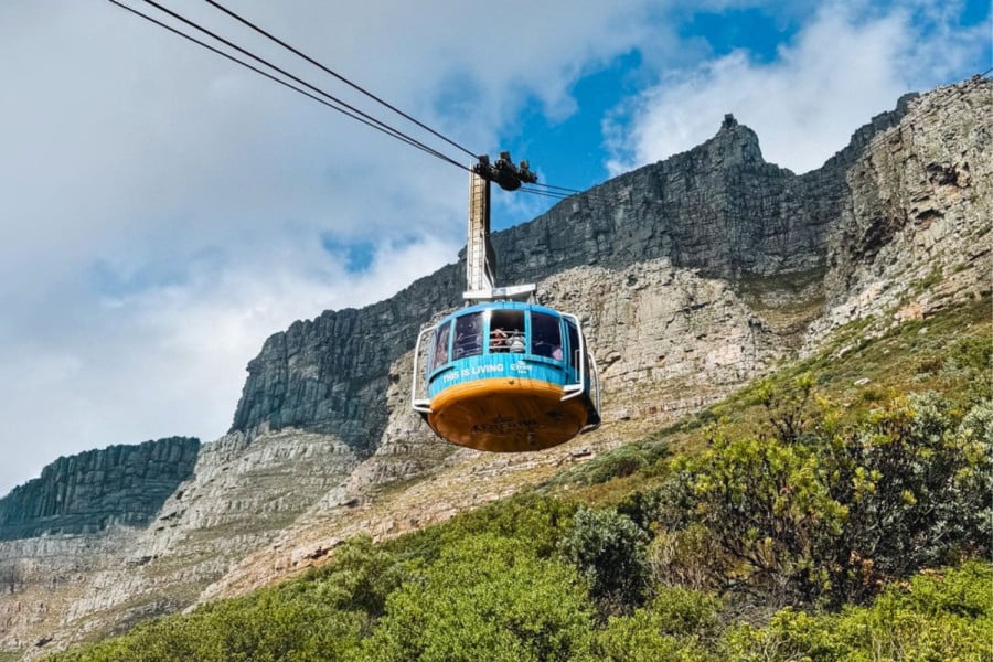 Cable car carrying people up a rocky mountainside in Cape Town, South Africa