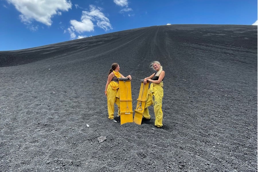 Two travellers going volcano boarding