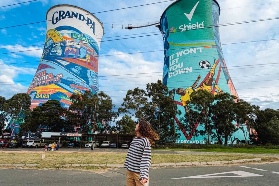 Person looking up at colourful murals on giant cooling towers in Johannesburg, South Africa