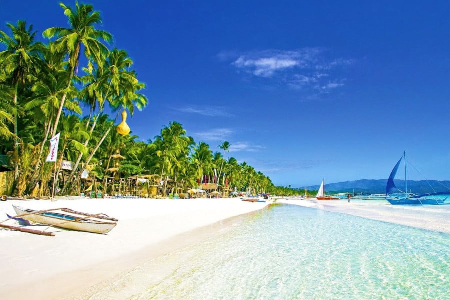 Sandy palm tree lined beach in Boracay in the Philippines